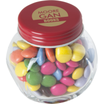 Kleine glazen pot gevuld met ca. 40 gr. choco carletties gekleurd deksel